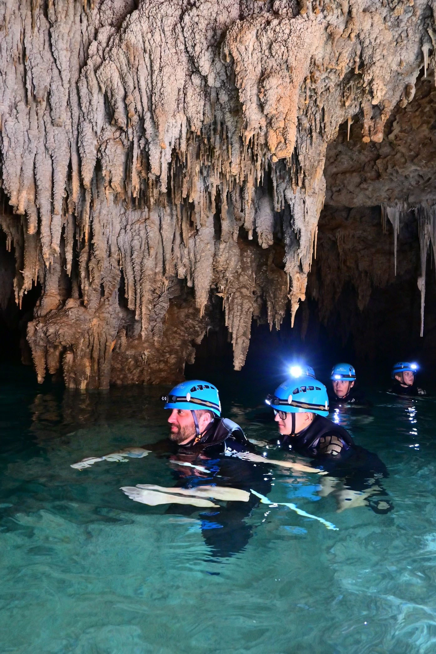 People in water in an underground cave